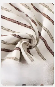 Gros plan sur un tricot rayé beige et marron doux avec une texture côtelée respirante