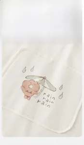 Détail de gilet pour bébé en maille beige avec broderie d'ours et poche de qualité