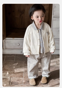 Detailed shot of baby boys plaid shirt, knit cardigan, and khaki pants three-piece set