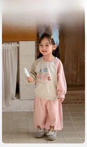 Detail of toddler girl tracksuit with cartoon bear print and soft cotton fabric texture