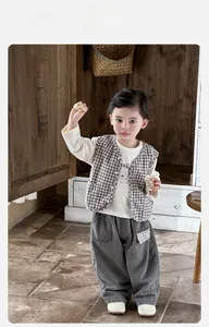 Detail of baby boy retro three-piece set with brown plaid vest, bear tee and gray pants