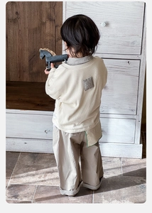 Detail view of toddler sweatshirt with plaid patchwork and matching khaki trousers back