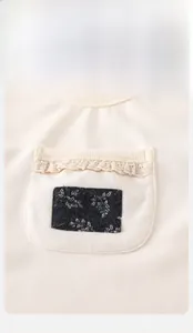 Dettaglio della felpa bimba in cotone beige a coste con tasca in pizzo e toppa a fiori