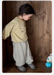 Dettaglio della felpa gialla per neonato con tasca Happy Bear e pantaloni a righe