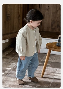 Tenue garçon avec cardigan beige, t-shirt blanc imprimé et jean large délavé