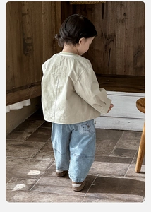 Vue détaillée du dos du cardigan beige et du jean bleu clair avec motif d'ours en dessin animé