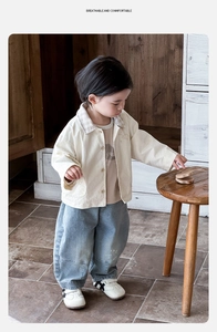 Détail de l'ensemble trois pièces pour garçon avec veste crème et jean bleu délavé