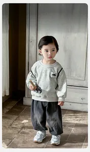 Close-up of baby gray sweatshirt set featuring cartoon car embroidery and ribbed cuffs