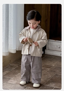 Detail of baby boy spring cargo outfit with beige jacket and purple utility pants