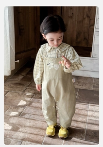 Détail de l'ensemble chemise à carreaux et salopette pour bébé avec broderie de chien