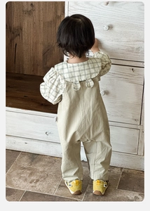 Détail du pantalon à bretelles beige pour enfant avec design oreilles de lapin au dos