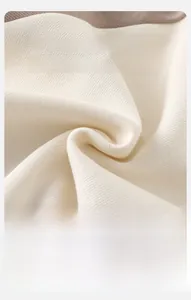 Macro shot of cream-colored knit fabric showing soft, breathable, and warm texture details