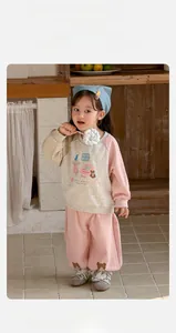 Detail of toddler girls pink loungewear set featuring a cartoon dog print and wide-leg pants