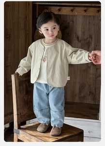 Détail de la veste beige pour enfant t-shirt ours et jean bleu clair droit