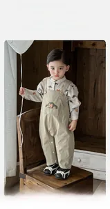 Detail of boys' cartoon bear print shirt and vintage khaki suspender pants outfit