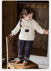 Dettaglio felpa neonata con tasca in pizzo e pantaloni a fiori coordinati set