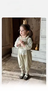 Detailansicht des geblümten Rüschenhemds und beigen Baumwoll-Overalls für Baby Mädchen