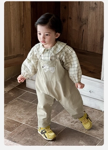 Détail de chemise à carreaux et salopette marron avec broderie de petit chien