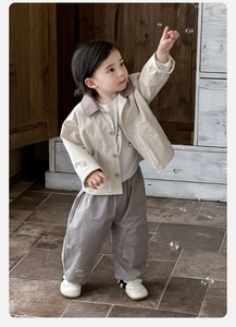 Three-piece boy outfit with beige jacket, white tee, and grey cargo pants in casual setting