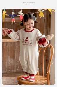 Detail of warm fleece baby romper with red ribbed cuffs and cute animal embroidery