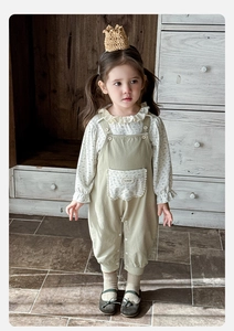 Detail von Baby-Blumenhemd mit Rüschenkragen und handgefertigtem Etikett auf der Hose
