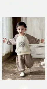 Close-up of baby tracksuit with cartoon dog embroidery and brown color-blocking detail