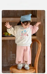 Detail of girls' cartoon bear sweatshirt and pink wide-leg pants outfit set