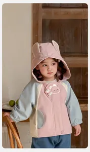 Detail of pink and blue girls hooded jacket with long rabbit ears and cloud embroidery