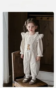 Détail de barboteuse bébé à pois avec motif lapin et finitions col à volants