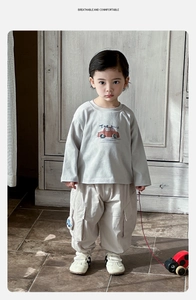 Detail of baby boy casual set featuring a grey car print t-shirt and beige cargo pants