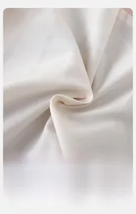 Macro shot of pearl white baby coat fabric showing soft texture and premium cotton weave