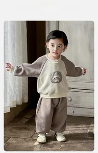 Detailed view of baby boy sport set with cartoon dog patch and ribbed cuffs on sweatshirt