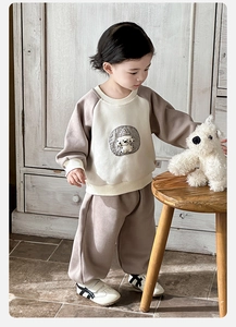 Detail of baby boy sporty two-piece set featuring a cartoon puppy patch and ribbed cuffs