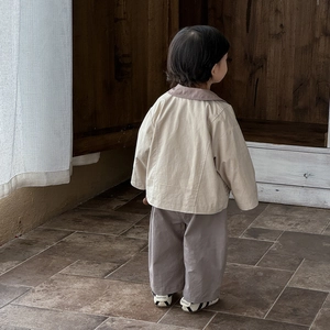 Three-piece baby boy clothing set with beige jacket and grey pants shown from the back