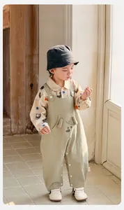 Detail of baby boy overall set with cartoon bear overall and horse print shirt