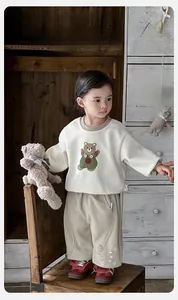 Detail von Baby-Bär-Sweatshirt und brauner Freizeithose aus weichem Baumwollstoff