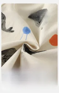 Close-up of soft beige cotton fabric with cute seal prints for baby clothing set