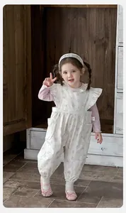 Detail of floral baby romper with ruffle straps and pink lace long sleeve undershirt