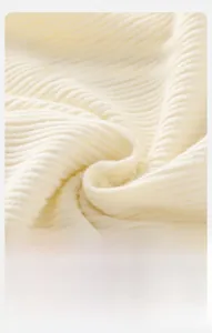 Macro detail of soft cream ribbed knit cotton fabric showing texture and elasticity