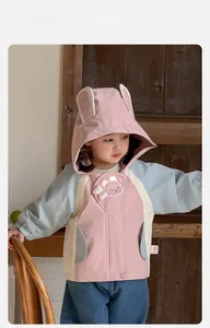 Detail of hooded jacket featuring cute long rabbit ears and a cartoon bear patch