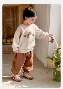Close-up of beige boys sweatshirt with lucky you text and brown bear prints