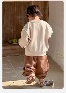 Detail view of cotton cream sweatshirt and brown joggers for toddler boys casual set