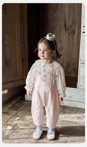 Close-up of floral blouse and pink overalls with cute rabbit embroidery and pearls