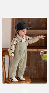 Detail of baby boy corduroy overalls with a 3D bear pocket and printed cotton shirt