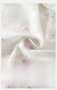 Detail of floral infant fabric with fine lace edges and soft woven texture