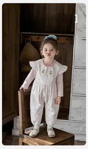 Detail of baby girl floral romper with ruffled Peter Pan collar and bear embroidery