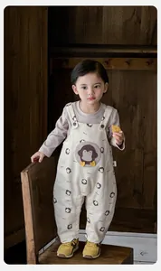 Detail of baby boy penguin pattern romper with button straps and ribbed cuffs