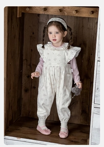 Detail of girls' floral jumpsuit with ruffle sleeves and pink long sleeve inner shirt