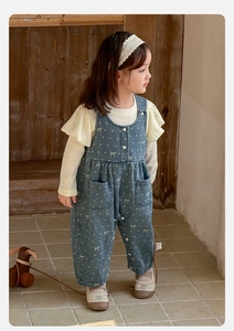 Detail of baby girl denim overalls with white polka dots and ruffled sleeve inner shirt