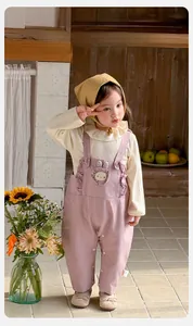 Détail d'une tenue pour bébé fille avec pull côtelé et salopette à volants lapin